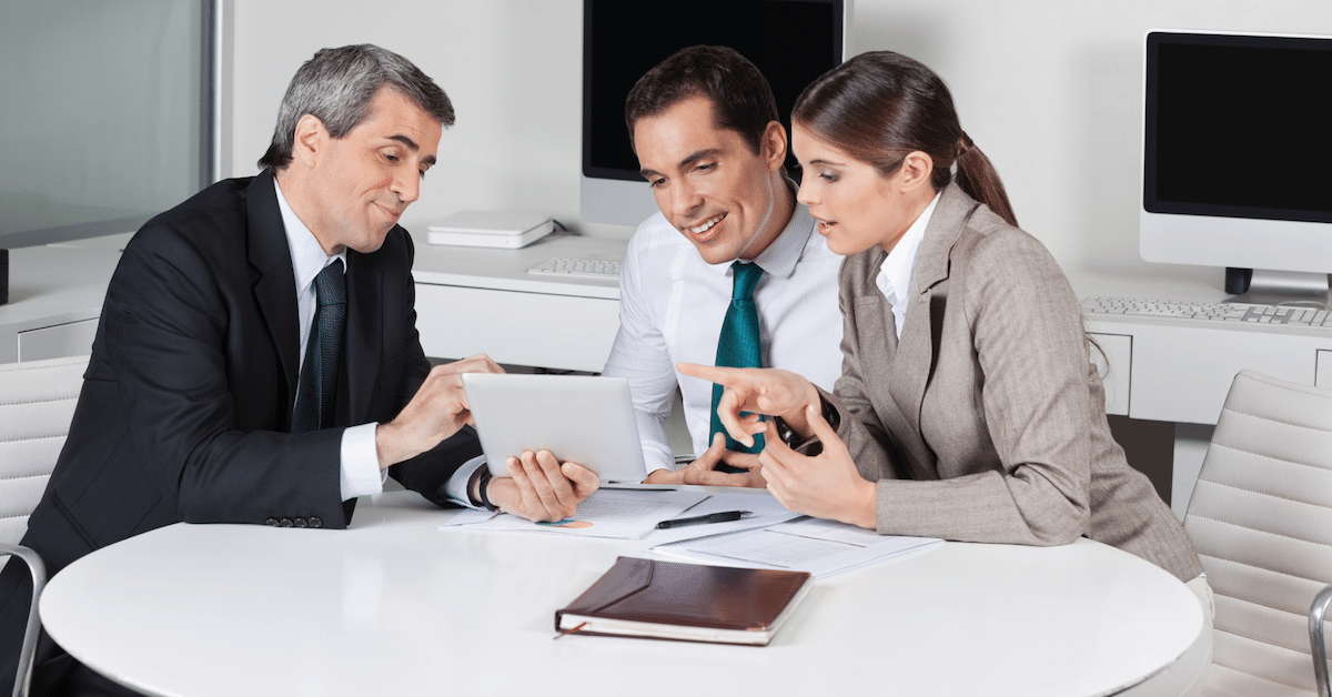 Multiple business people looking at a tablet