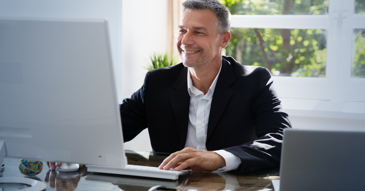 Man smiling while using computer