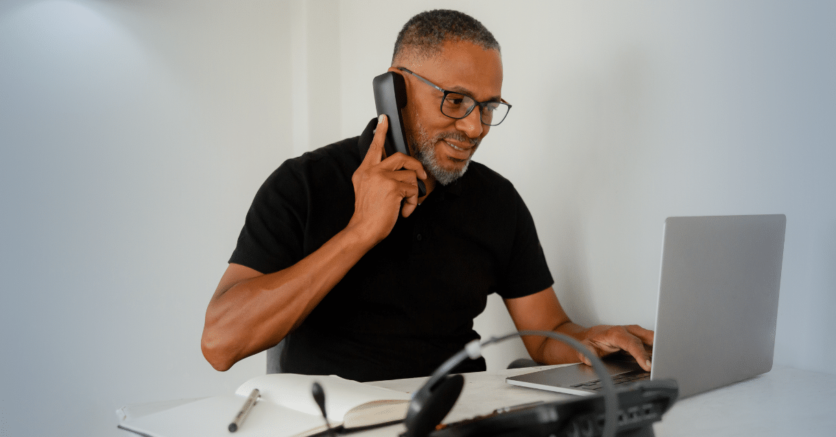 Man speaking on the phone while at the computer