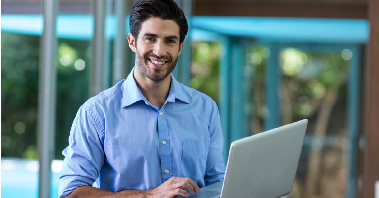 Man smiling while holding a computer